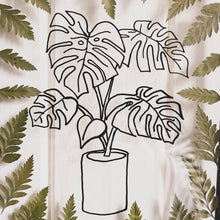 Load image into Gallery viewer, Close up of Handcrafted pressed flower frame featuring hand drawn Monstera Leaf. With fern leaves circling the drawing in a black glass frame, perfect for home decor
