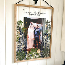 Load image into Gallery viewer, A side angle of handcrafted pressed flower frame featuring a couple's wedding photo, vibrant lupins and pink roses, perfect for home decor.