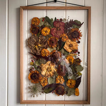 Load image into Gallery viewer, A wedding bouquet in rich autumnal colours, beautifully pressed and framed in natural wood, becomes a timeless keepsake. The vibrant hues of rust, gold, and deep burgundy are captured in perfect harmony, preserving the warmth and beauty of your special da
