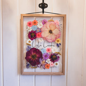 Handcrafted pressed flower frame featuring a vibrant pink hues, perfect for home decor.