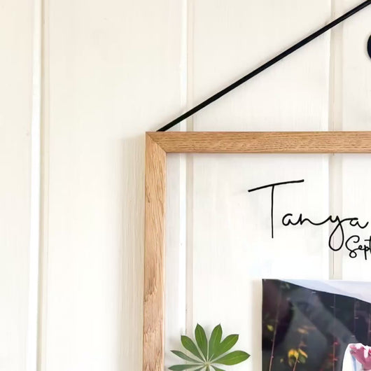 A close up corner image of handcrafted pressed flower frame featuring a couple's wedding photo, vibrant lupins and pink roses, perfect for home decor.