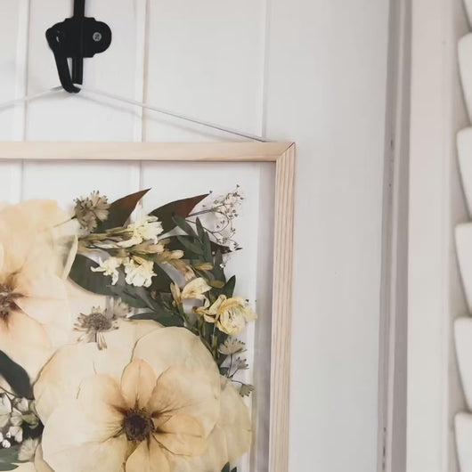 A corner angel of Bridal pressed flower frame featuring brides original flowers with in it.